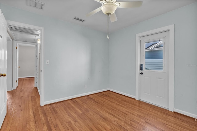 spare room featuring ceiling fan, light wood finished floors, visible vents, and baseboards