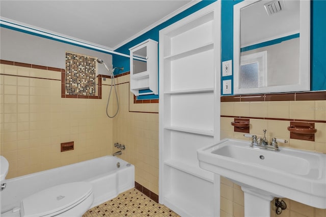 full bathroom with toilet, a sink, tile walls, and bathing tub / shower combination