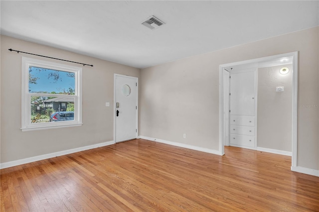 interior space with light wood finished floors, visible vents, and baseboards