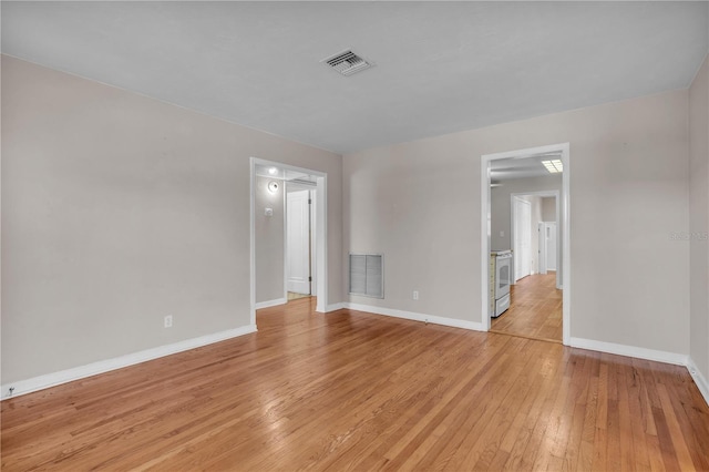 empty room featuring baseboards, visible vents, and light wood-style floors