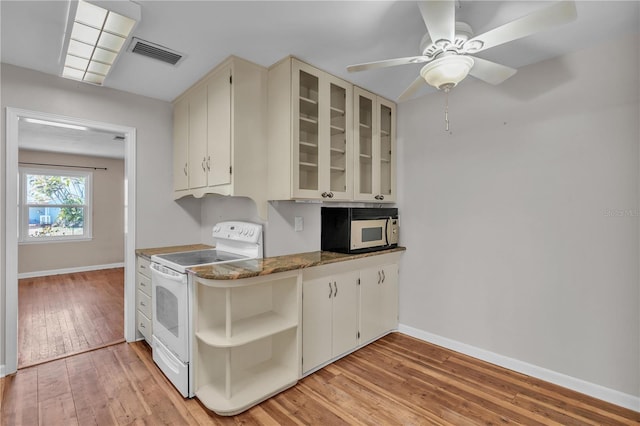 kitchen with electric range, visible vents, baseboards, glass insert cabinets, and light wood-type flooring