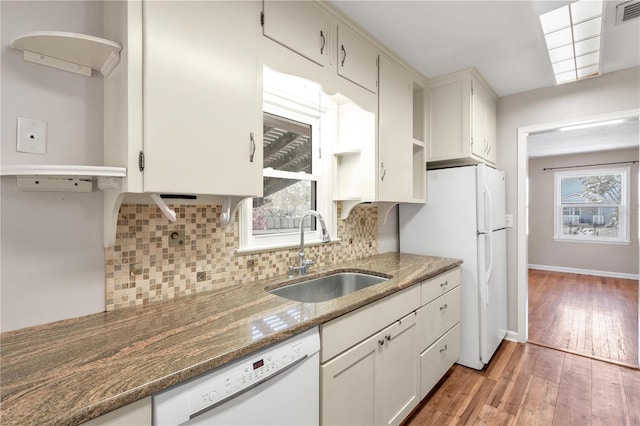 kitchen featuring white appliances, decorative backsplash, light wood-type flooring, open shelves, and a sink