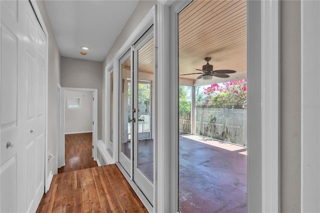 doorway with ceiling fan, baseboards, and wood finished floors