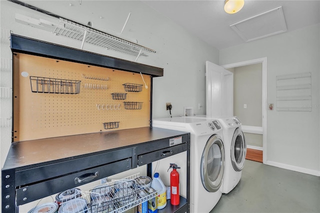 laundry area featuring attic access, baseboards, and washing machine and clothes dryer