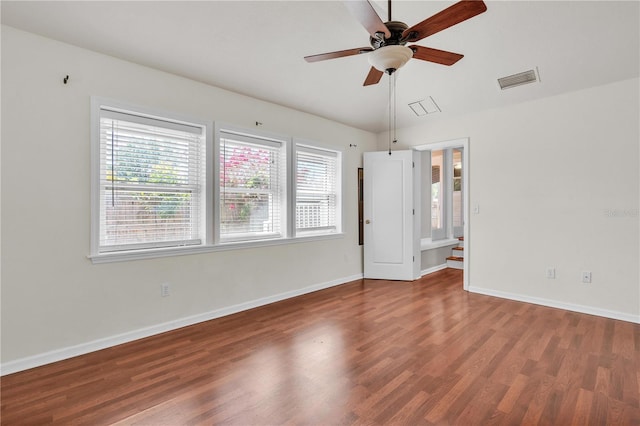 spare room featuring visible vents, ceiling fan, baseboards, and wood finished floors