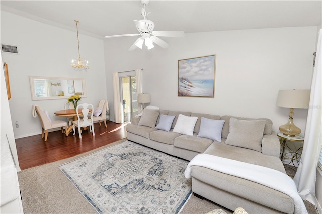 living area featuring high vaulted ceiling, visible vents, wood finished floors, and ceiling fan with notable chandelier