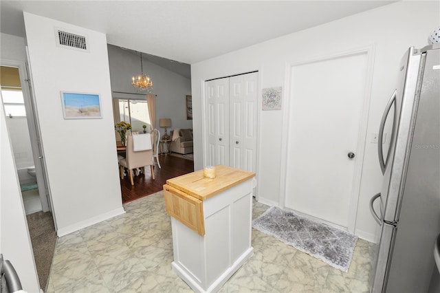 entryway featuring a chandelier, marble finish floor, plenty of natural light, and visible vents