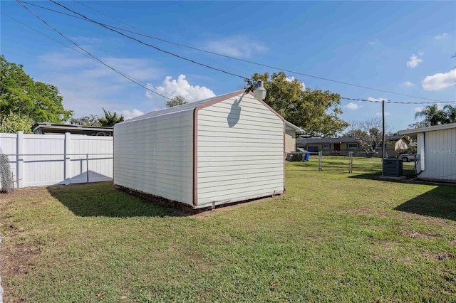 view of shed with cooling unit and a fenced backyard