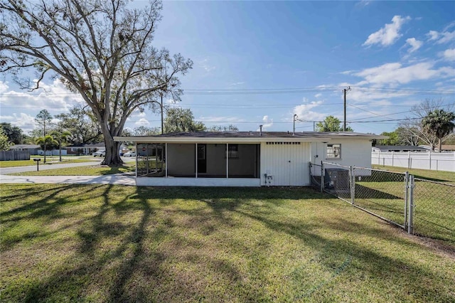 rear view of property with fence, a sunroom, a lawn, a gate, and a carport