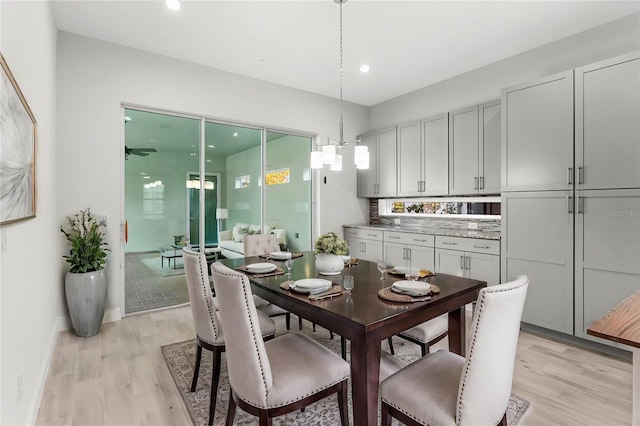 dining area featuring baseboards, light wood-type flooring, a notable chandelier, and recessed lighting