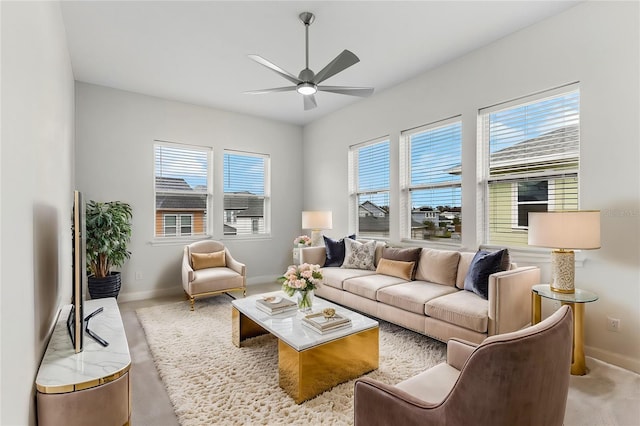 living area with baseboards, a ceiling fan, and carpet flooring