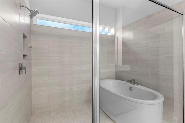 full bath featuring tile walls, a freestanding bath, and a shower stall