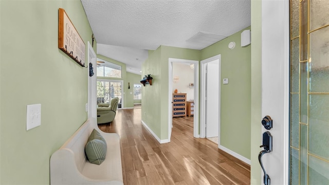 foyer with wood finished floors, baseboards, and a textured ceiling