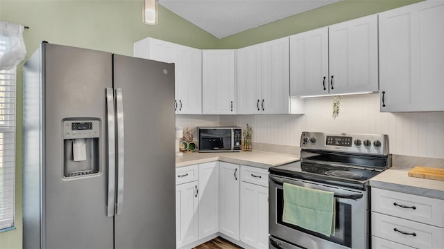 kitchen featuring white cabinets, stainless steel appliances, and light countertops