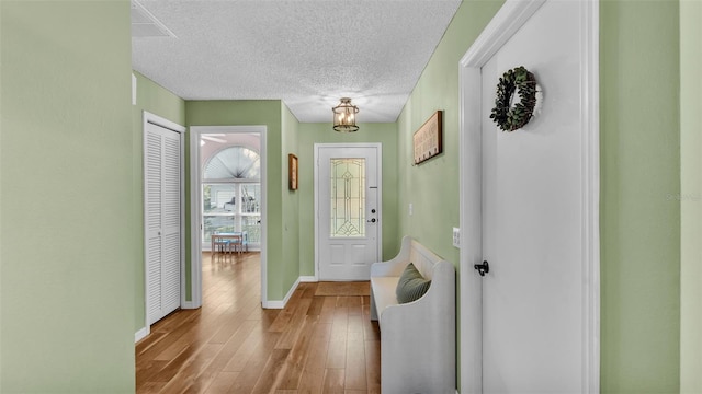 entryway with baseboards, a textured ceiling, and wood finished floors