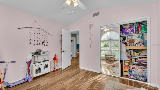 game room with visible vents, a ceiling fan, lofted ceiling, and wood finished floors