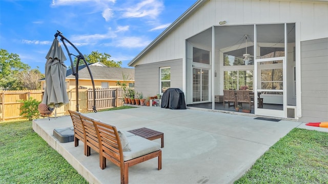 view of patio featuring fence and a sunroom