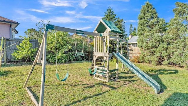 view of playground featuring fence and a lawn