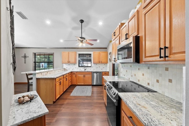 kitchen with visible vents, a peninsula, ceiling fan, dark wood-type flooring, and appliances with stainless steel finishes