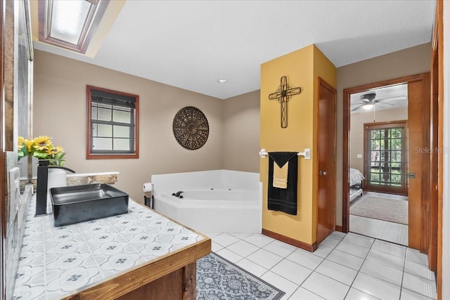 bathroom with baseboards, a garden tub, vanity, and tile patterned flooring