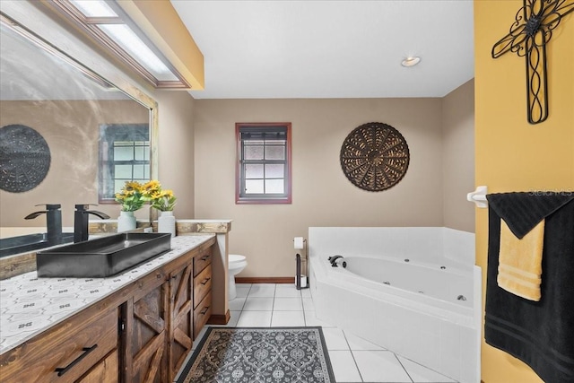 full bath featuring tile patterned floors, toilet, a whirlpool tub, baseboards, and vanity