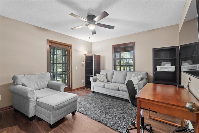 living room with baseboards, wood finished floors, a textured ceiling, and ceiling fan