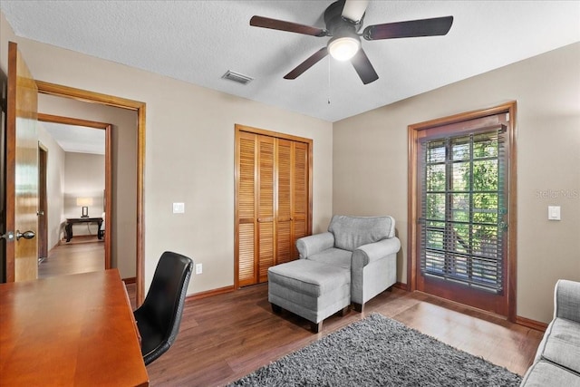 home office with baseboards, wood finished floors, visible vents, and ceiling fan