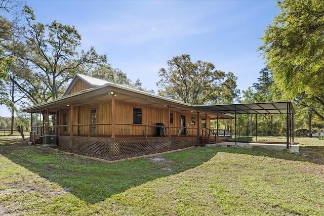 exterior space featuring a carport, covered porch, central AC unit, and a yard