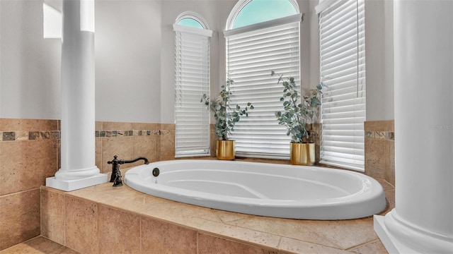 bathroom with a garden tub and decorative columns