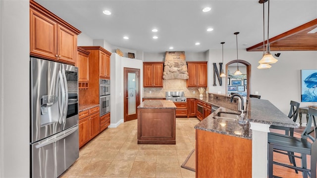 kitchen featuring premium range hood, a sink, a center island, stainless steel appliances, and decorative backsplash