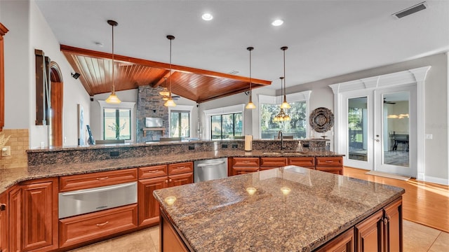 kitchen with visible vents, lofted ceiling with beams, stainless steel dishwasher, a warming drawer, and tasteful backsplash