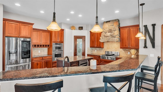 kitchen with backsplash, brown cabinets, and appliances with stainless steel finishes