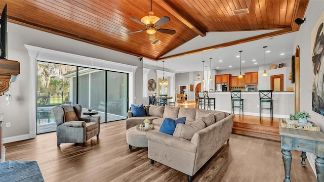 living room featuring visible vents, baseboards, light wood-style flooring, vaulted ceiling with beams, and wood ceiling