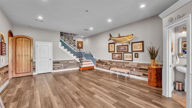 living area featuring visible vents, stairs, recessed lighting, wood finished floors, and arched walkways