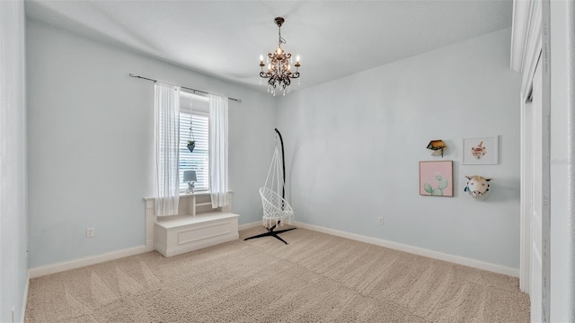 unfurnished room featuring baseboards, light colored carpet, and a chandelier