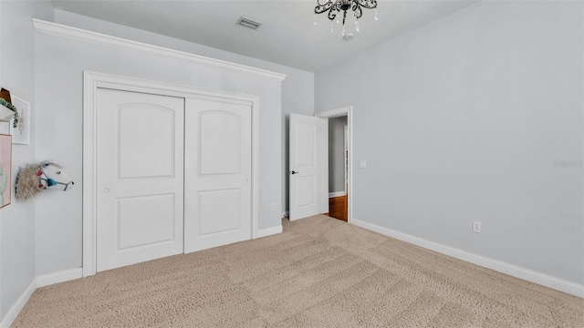 unfurnished bedroom featuring visible vents, baseboards, carpet, and a closet