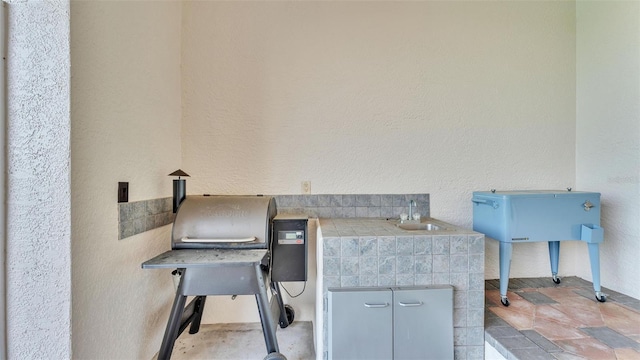 miscellaneous room with a textured wall and a sink