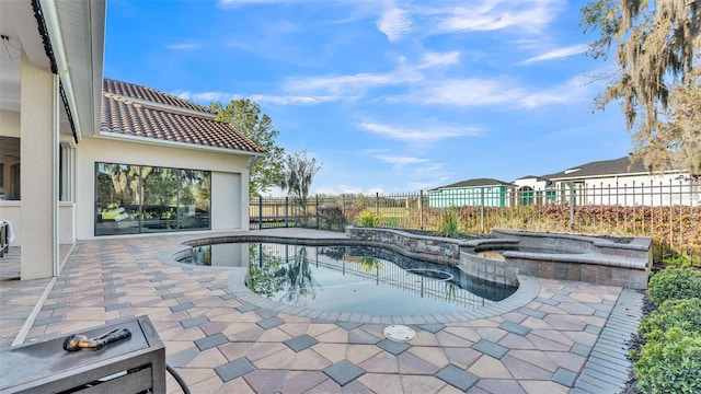 view of pool featuring a patio, a fenced backyard, and a pool with connected hot tub