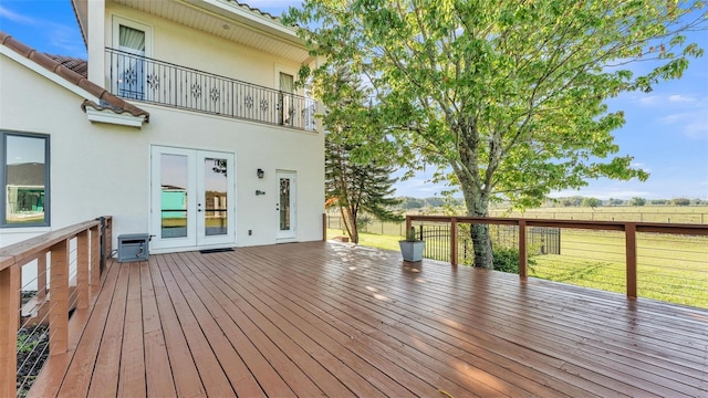 deck featuring french doors, a lawn, and fence