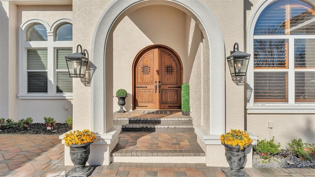 doorway to property featuring stucco siding