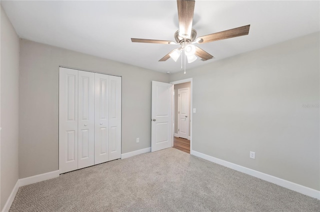 unfurnished bedroom with a closet, baseboards, carpet floors, and ceiling fan