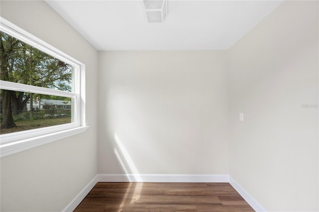 spare room featuring wood finished floors and baseboards