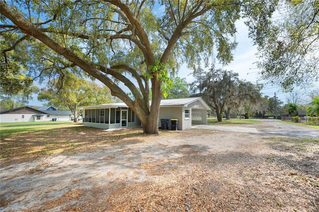 view of front of house featuring driveway and a sunroom