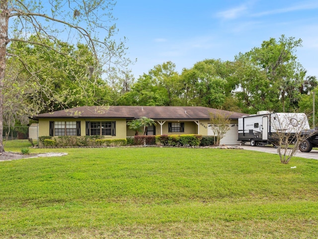 ranch-style home featuring stucco siding, driveway, and a front yard