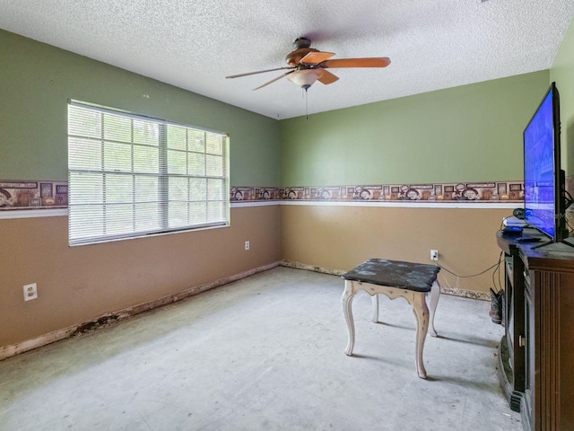 interior space with a textured ceiling and ceiling fan