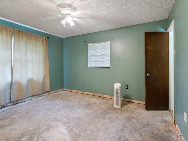 unfurnished room featuring a textured ceiling, unfinished concrete flooring, baseboards, and ceiling fan