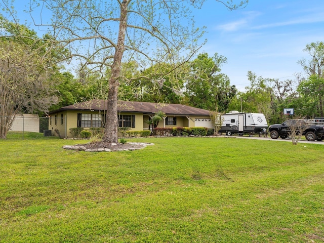 view of front of property featuring a front yard, a garage, and stucco siding