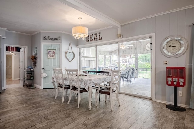 dining area featuring crown molding, wood finished floors, and baseboards