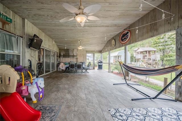 unfurnished sunroom featuring ceiling fan