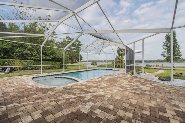 view of swimming pool featuring a patio area, glass enclosure, and a pool with connected hot tub